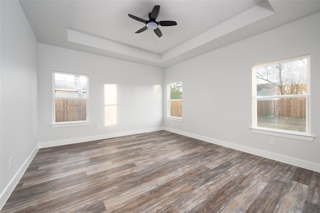 411 West Elm Street Whitewright, TX 75491 - Photo 15 of 31 a view of an empty room with a window and wooden floor
