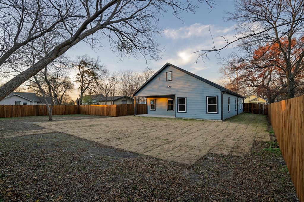 411 West Elm Street Whitewright, TX 75491 - Photo 19 of 31 a view of a house with a yard covered in the forest