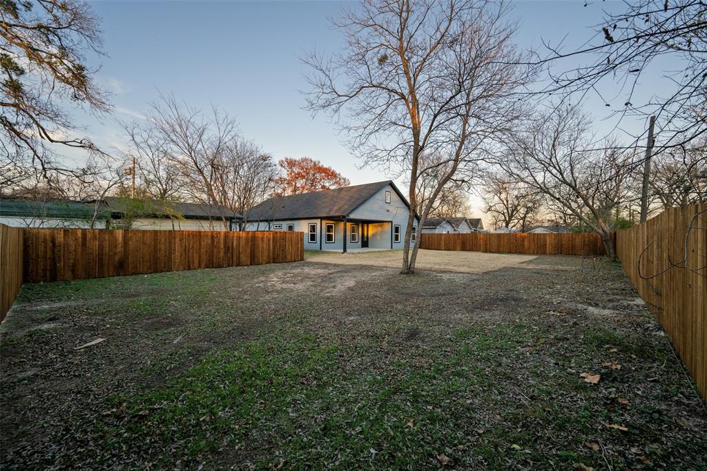 411 West Elm Street Whitewright, TX 75491 - Photo 21 of 31 a view of a yard with large trees and wooden fence