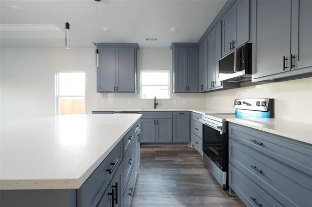 a kitchen with stainless steel appliances sink cabinets and window