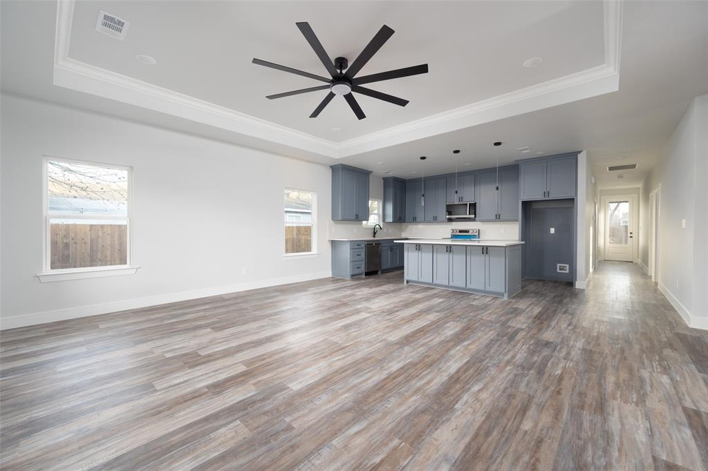 411 West Elm Street Whitewright, TX 75491 - Photo 31 of 31 Kitchen with open floor plan, light countertops, a raised ceiling, and ornamental molding