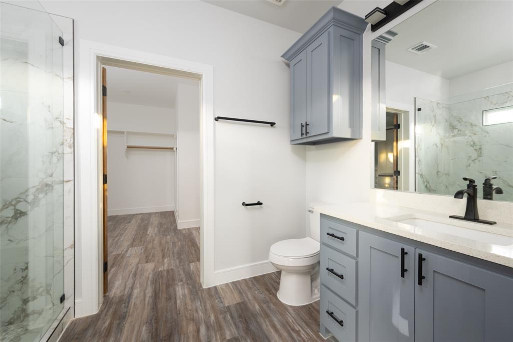 411 West Elm Street Whitewright, TX 75491 - Photo 6 of 26 a bathroom with a granite countertop sink toilet and shower