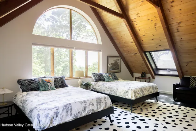 a bedroom with two beds and a large window