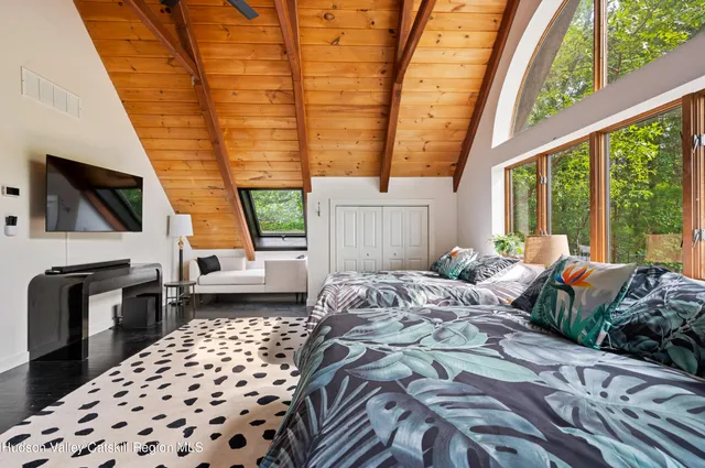 a bedroom with a bed next to a large window with the outer view