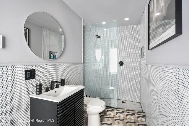 a bathroom with a sink a toilet a mirror and shower