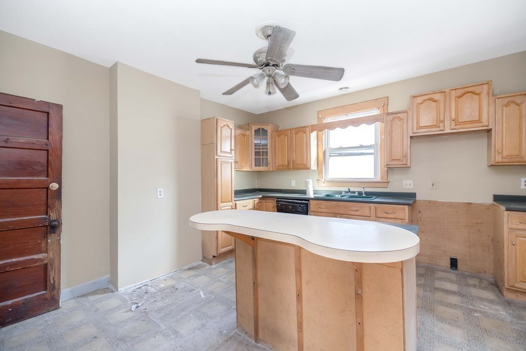 7-9 Cornell Street Springfield, MA 01109 - Photo 16 of 40 a kitchen with stainless steel appliances granite countertop a sink a stove a refrigerator with white cabinets and couches