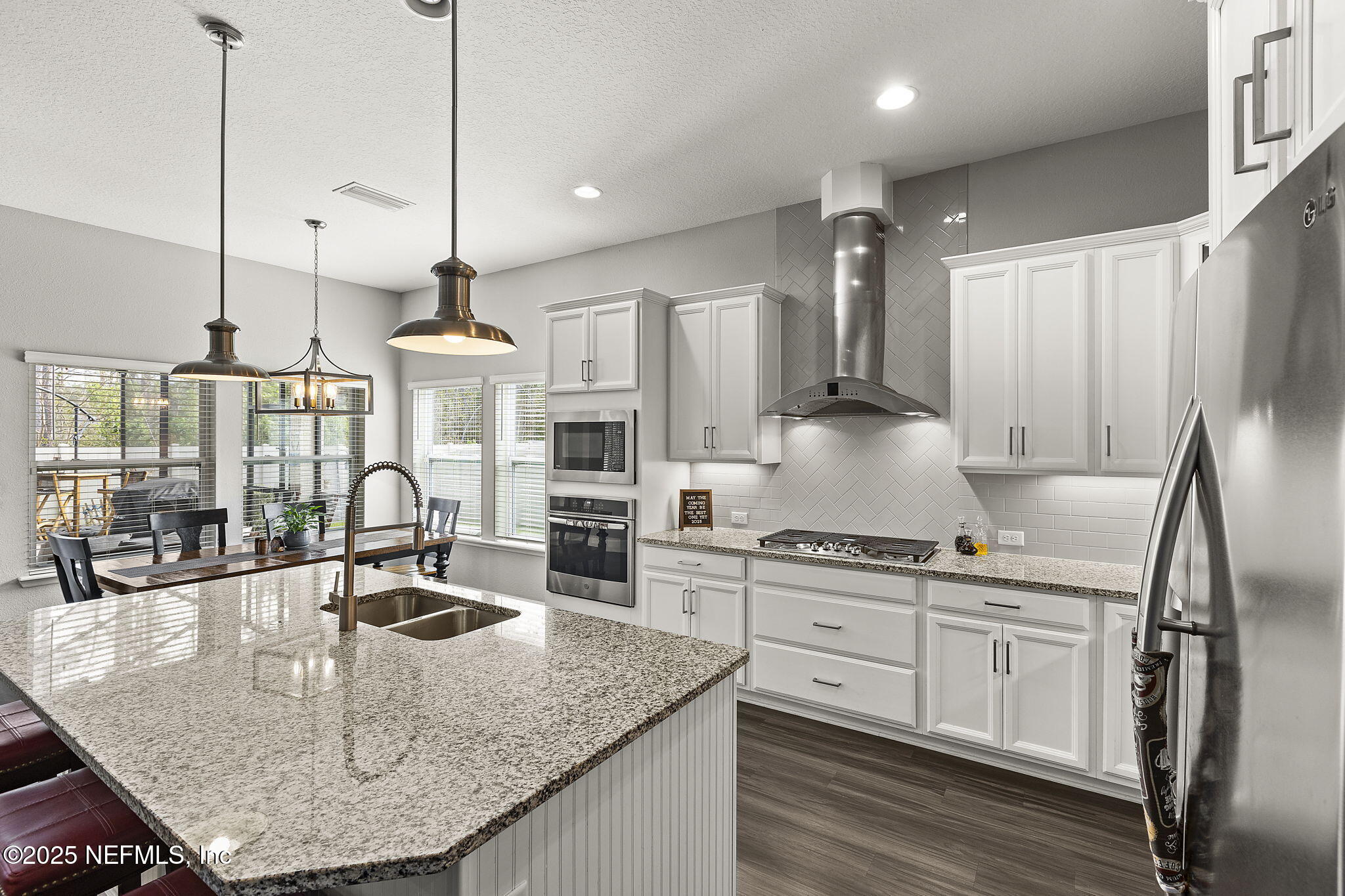 45 Manor Lane St. Johns, FL 32259 - Photo 15 of 47 a kitchen with stainless steel appliances granite countertop a sink a stove and a wooden floor