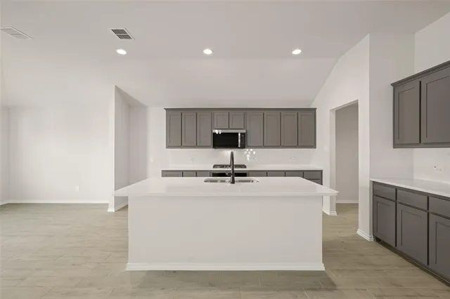 a view of a kitchen with sink dishwasher and wooden cabinets