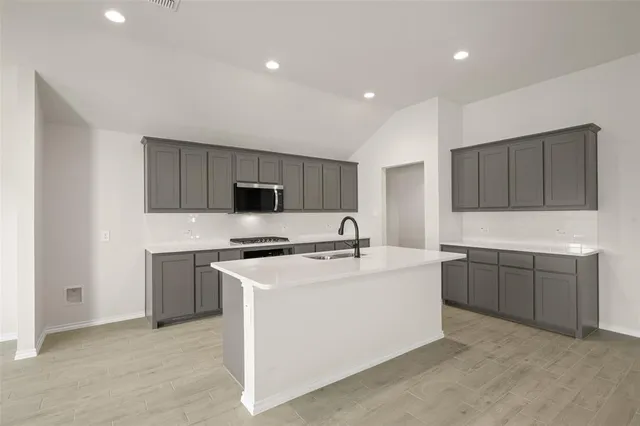 a kitchen with cabinets a sink and white appliances