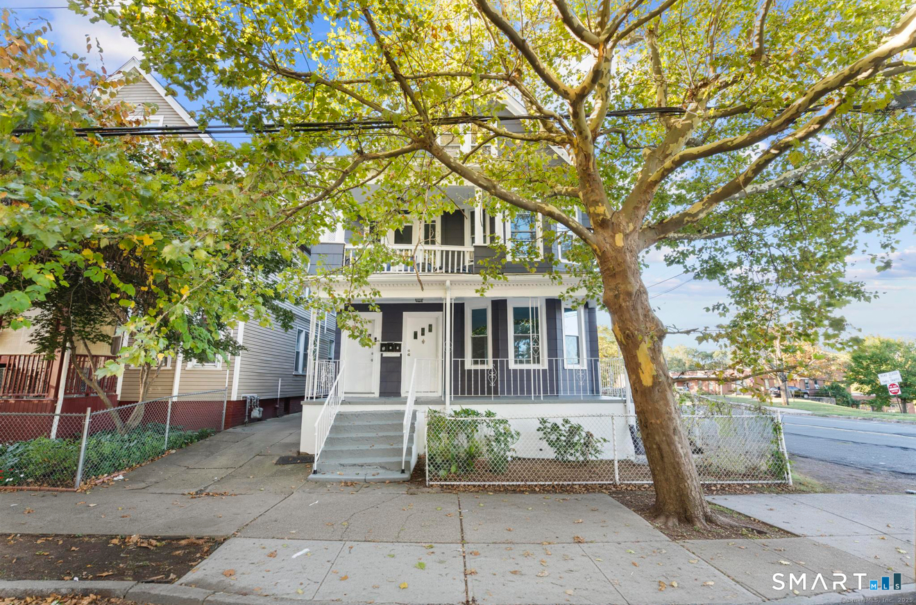 a front view of a house with a tree