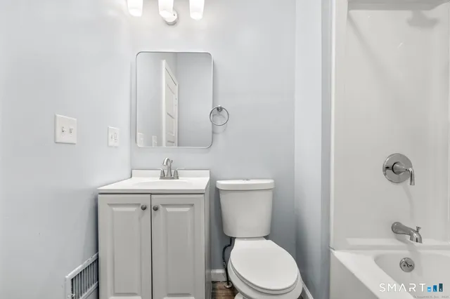 a bathroom with a toilet a sink and mirror