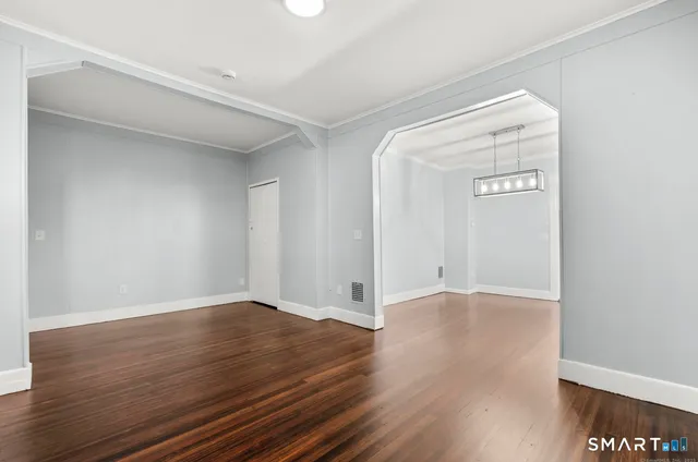 a view of an empty room with wooden floor