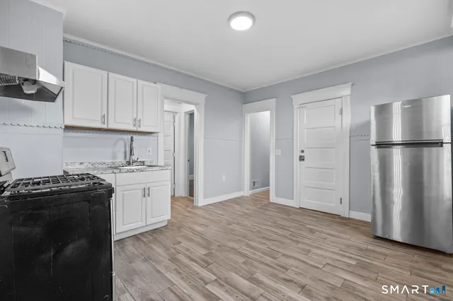 a kitchen with granite countertop a refrigerator stove top oven and sink