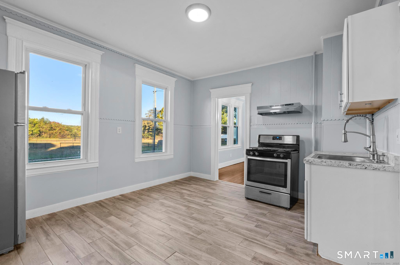292 West Ivy Street New Haven, CT 06511 - Photo 10 of 16 a kitchen with stainless steel appliances a stove a sink and white cabinets with wooden floor