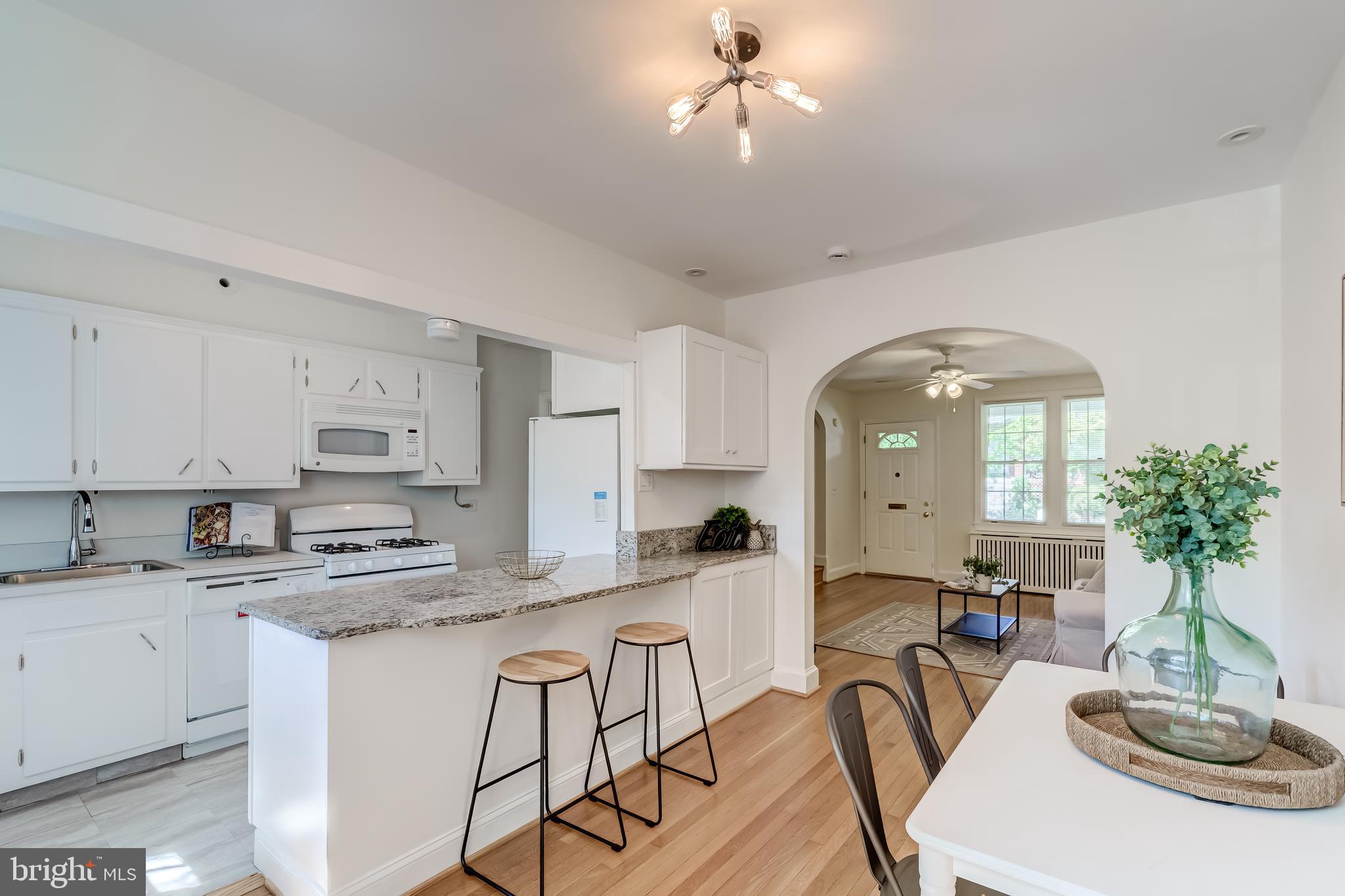 2217 39th Place Northwest Washington, DC 20007 - Photo 6 of 28 a kitchen with stainless steel appliances a sink a stove a dining table and chairs