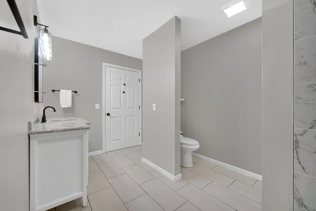 a bathroom with a granite countertop sink and toilet