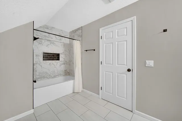 a view of a bathroom with a bathtub and shower