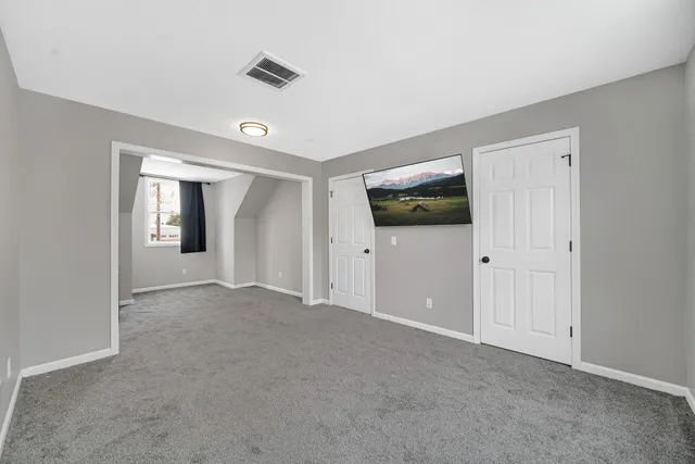 a view of an empty room with window and closet area
