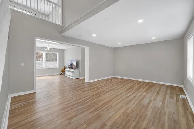 a view of empty room with wooden floor