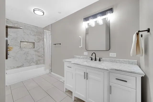 a bathroom with a granite countertop sink mirror and bathtub