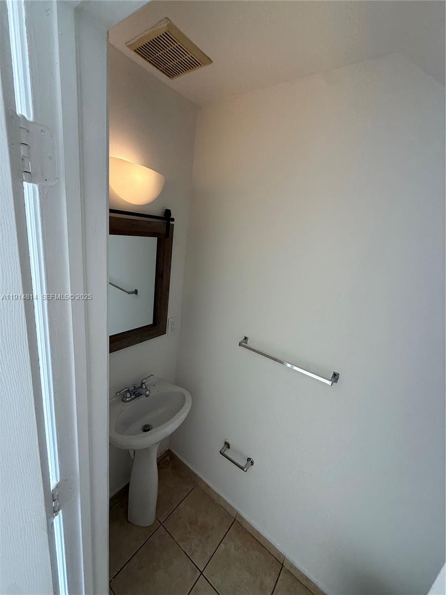 821 Southwest 2nd Street, Unit 7 Miami, FL 33130 - Photo 17 of 29 a bathroom with a toilet sink and mirror