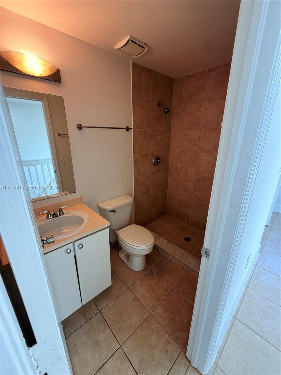 821 Southwest 2nd Street, Unit 7 Miami, FL 33130 - Photo 29 of 29 a bathroom with a granite countertop sink toilet a mirror and shower