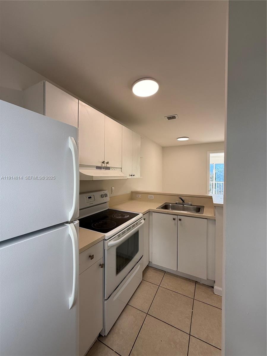 821 Southwest 2nd Street, Unit 7 Miami, FL 33130 - Photo 6 of 29 a kitchen with granite countertop white cabinets and white appliances