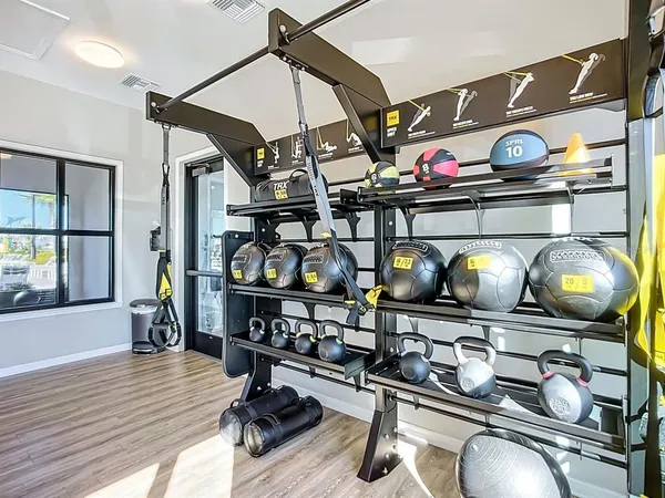 a room with gym equipment and wooden floor