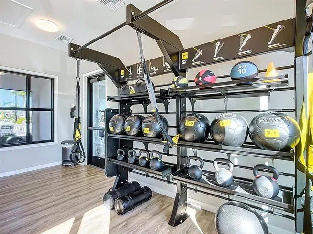 a room with gym equipment and wooden floor