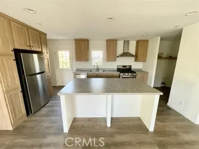 a kitchen with stainless steel appliances granite countertop a refrigerator a stove and a sink