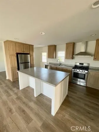 a kitchen with stainless steel appliances granite countertop a sink a stove and a refrigerator