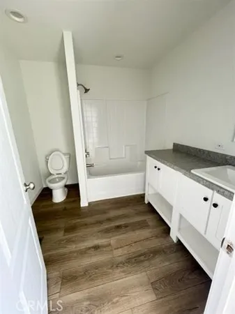 a view of a kitchen with white cabinets and wooden floor