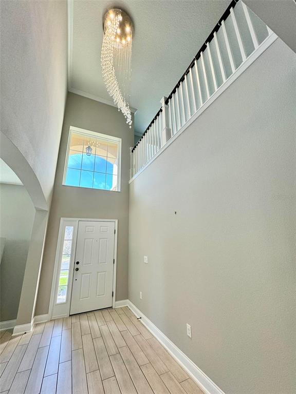 12411 Northover Loop Orlando, FL 32824 - Photo 5 of 13 a view of a hallway with entryway wooden floor and front door