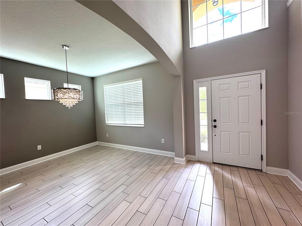 12411 Northover Loop Orlando, FL 32824 - Photo 7 of 13 a view of an empty room with wooden floor and a window