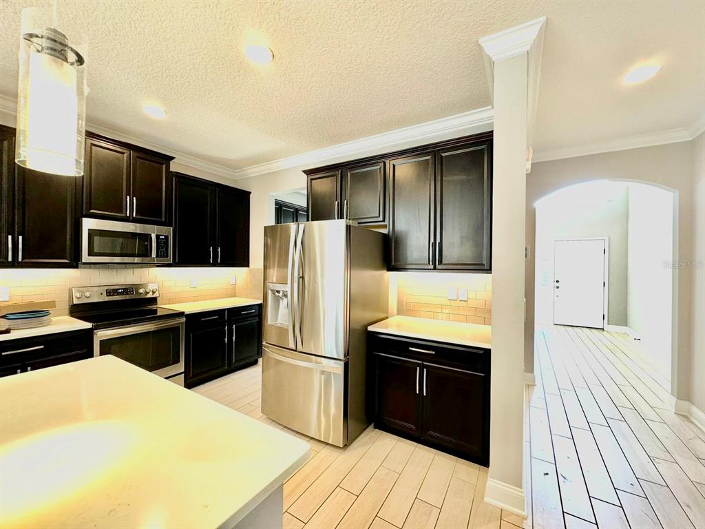 12411 Northover Loop Orlando, FL 32824 - Photo 9 of 13 a kitchen with stainless steel appliances a stove a sink and a refrigerator