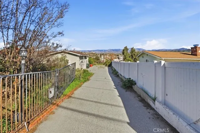 a view of a pathway with a wrought fence