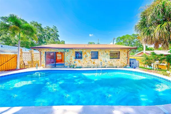 a view of a house with swimming pool and a yard
