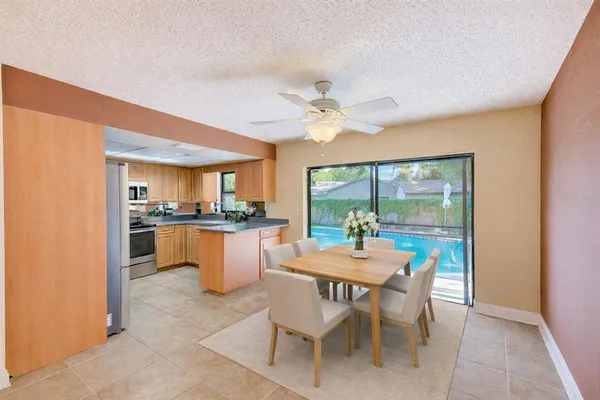 a dining room with wooden floor and a floor to ceiling window
