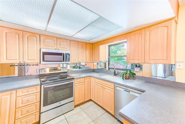 a kitchen with stainless steel appliances granite countertop a stove a sink and a microwave