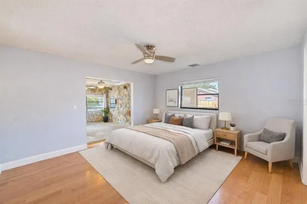 a bedroom with a bed and wooden floor