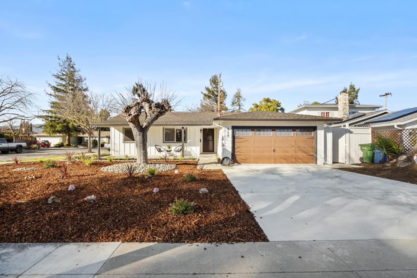 a front view of a house with a yard and potted plants