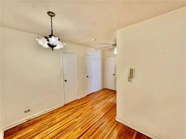 a view of a room with wooden floor and chandelier
