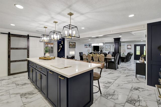 a large kitchen with kitchen island a sink table and chairs