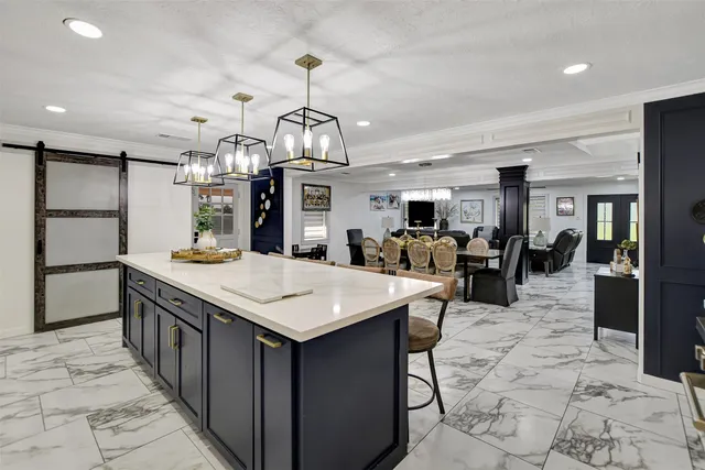 a large kitchen with kitchen island a sink table and chairs