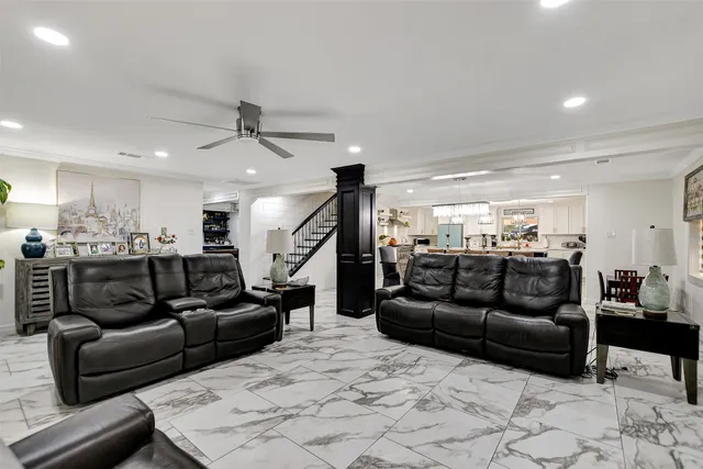 a living room with furniture and a ceiling fan
