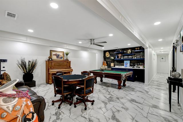 a room with furniture pool table and flat screen tv