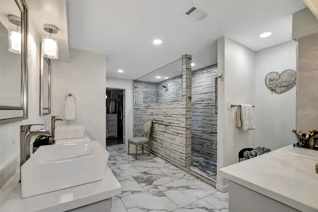 a spacious bathroom with a double vanity sink a mirror and a