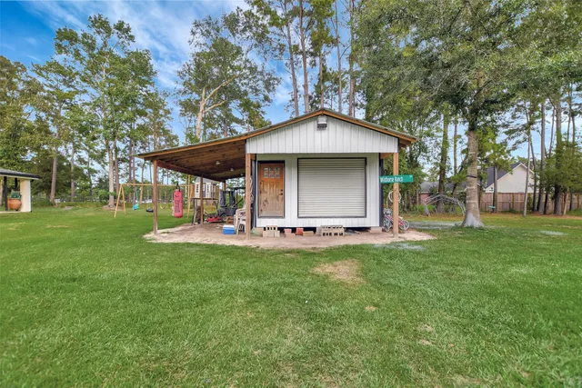 a view of a small house with a small yard and large tree