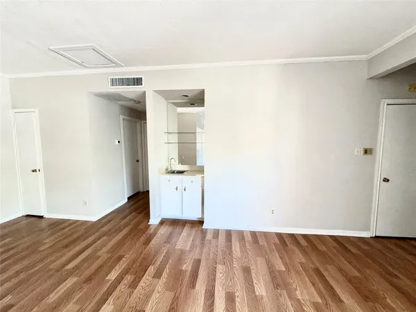 a view of a room with wooden floor and a white bed