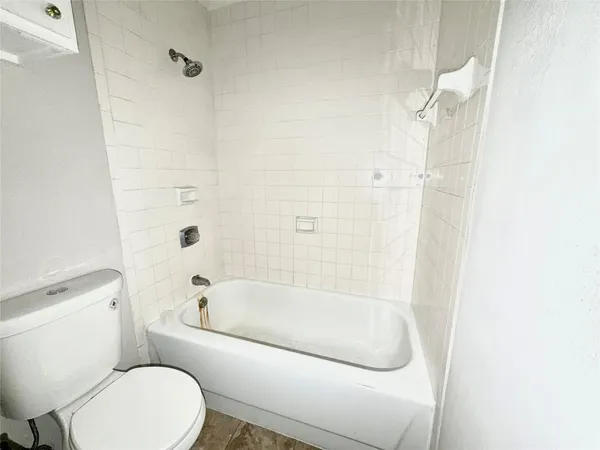 a white bath tub sitting next to a toilet